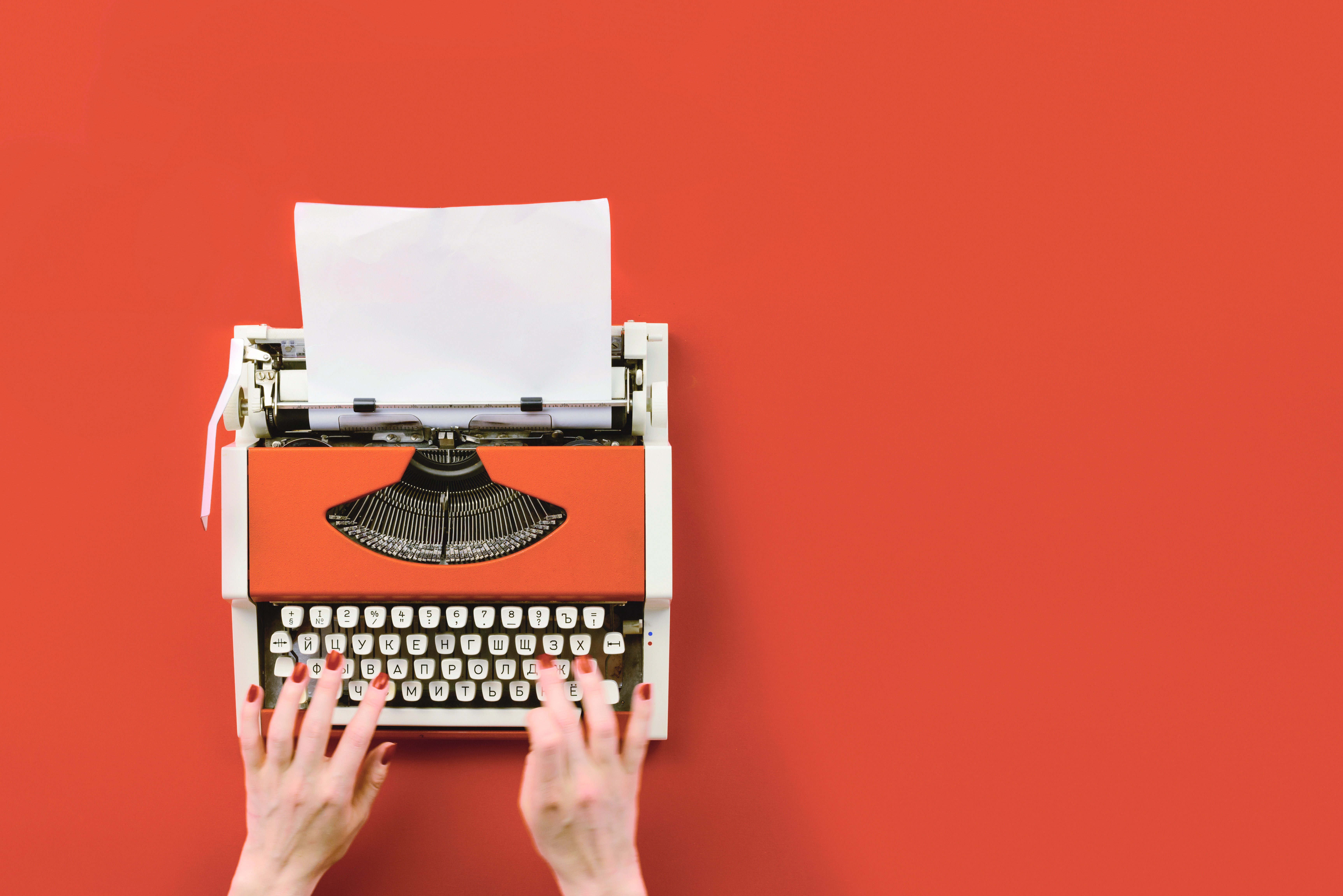 typewriterorange-1.jpg hands-typing-on-typewriter-orange-background